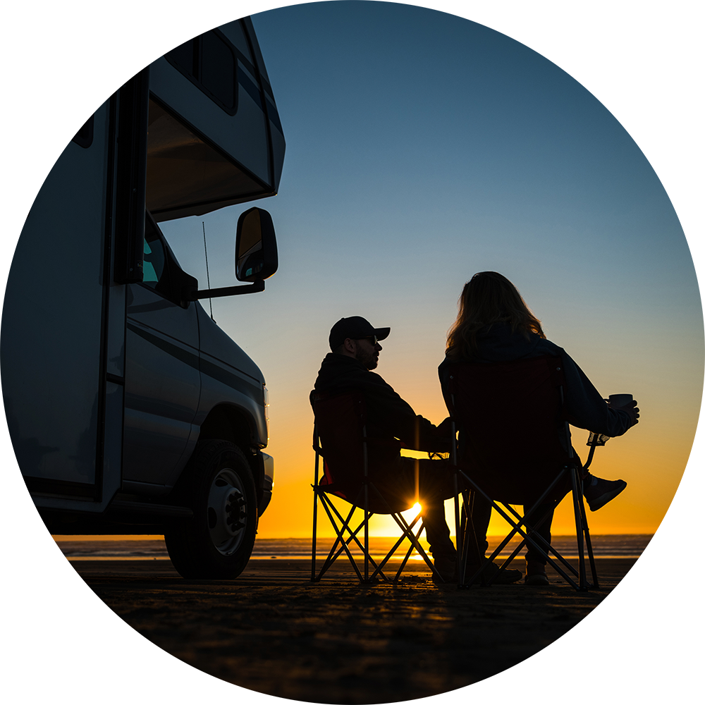 Couple watching a sunset next to their motorhome after an RV inspection